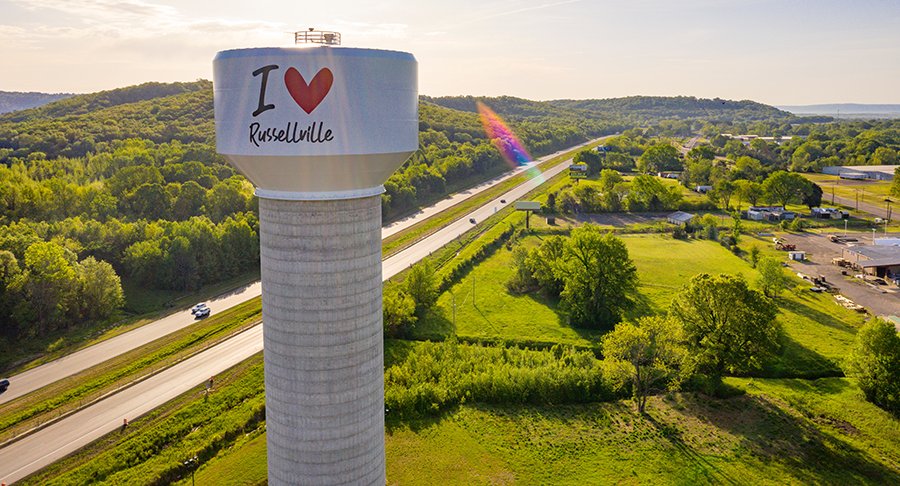 The I love Russellville water tower above the trees